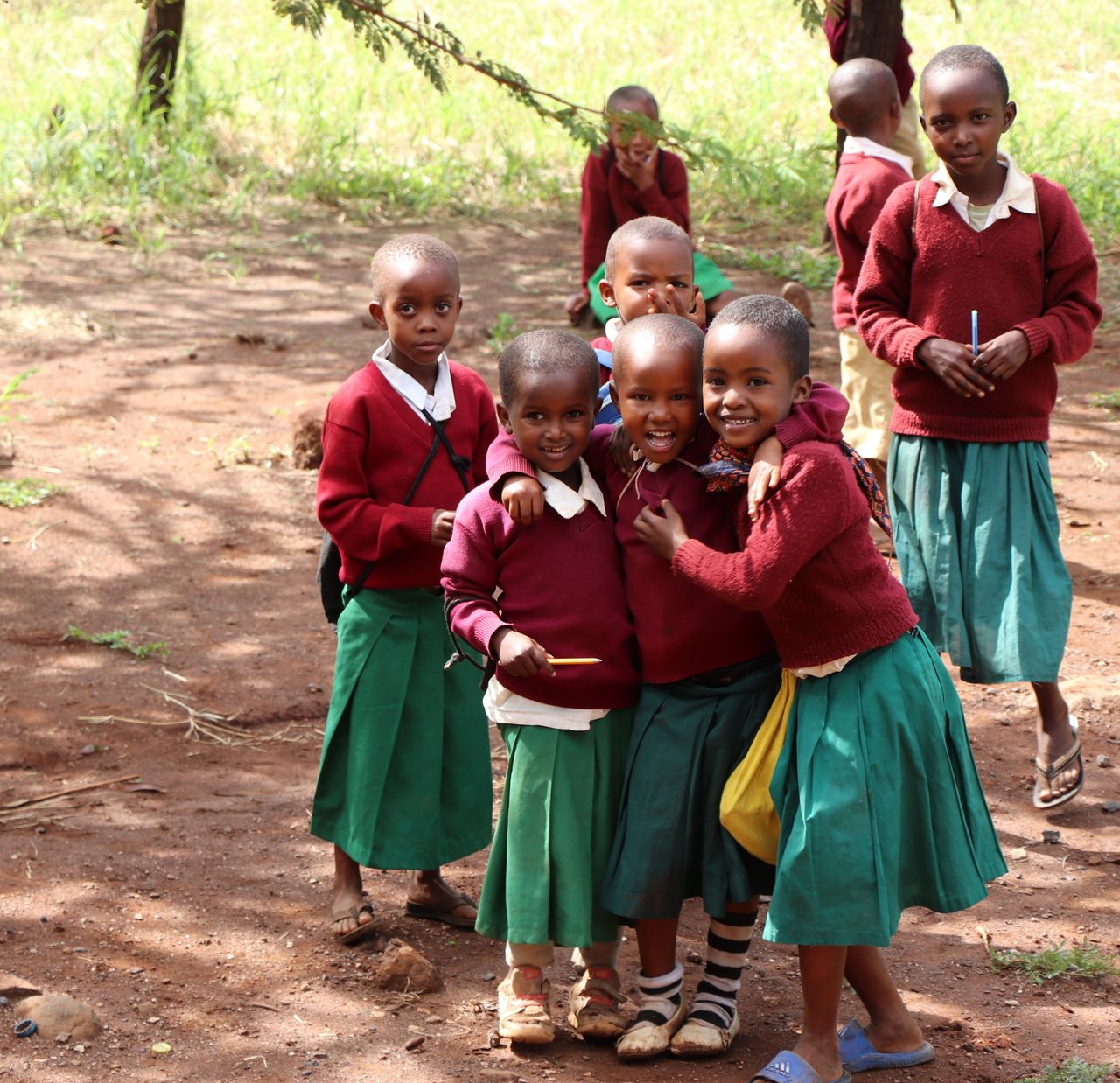 Joyful children in school uniforms playing outdoors, showing camaraderie and happiness.