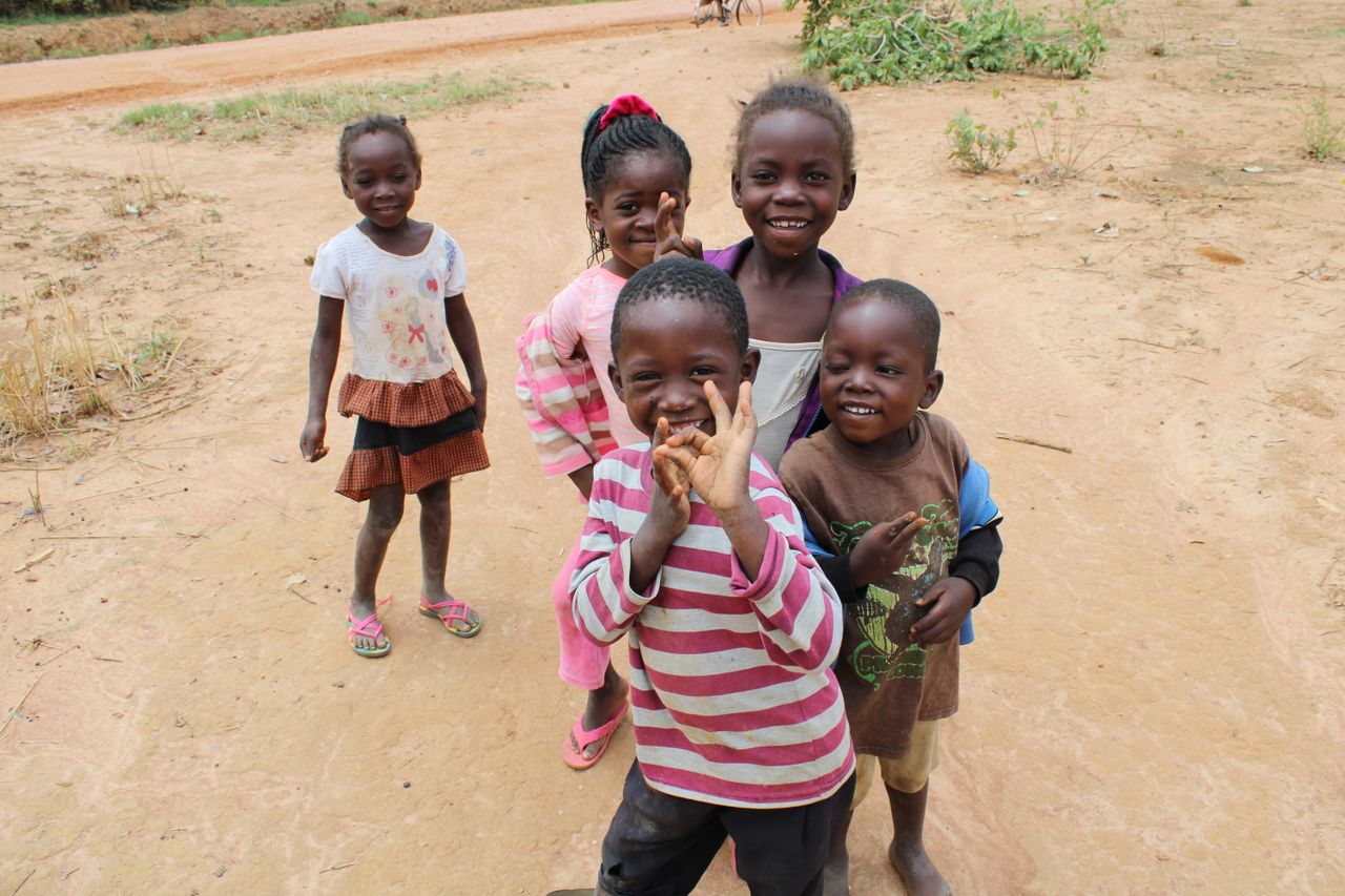 The Art of Drawing Readers In: Your attractive post title goes here Group of cheerful children playing on a dirt road in Zambia, showcasing joy and friendship.
